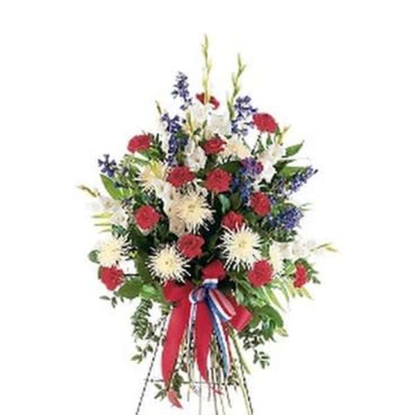 Standing floral spray with red, white, and blue flowers on an easel