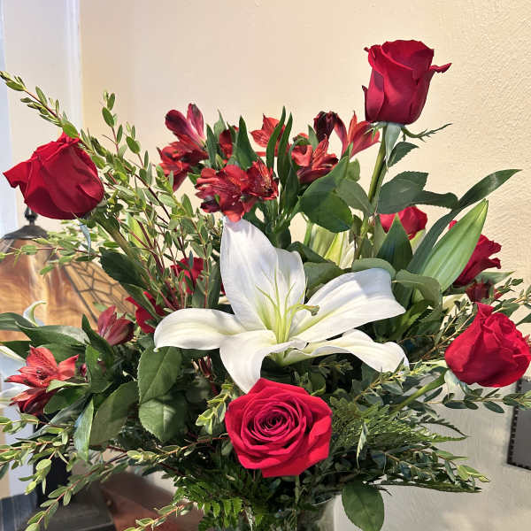 Bouquet of red roses and white lilies in a glass vase