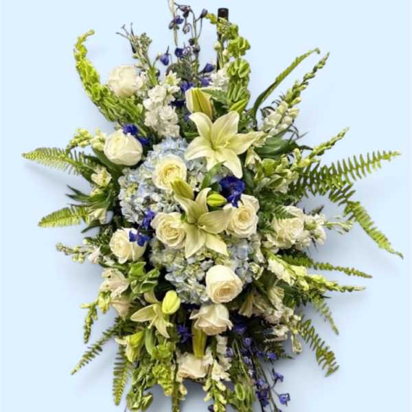 Standing floral spray with white lilies, roses, and blue flowers