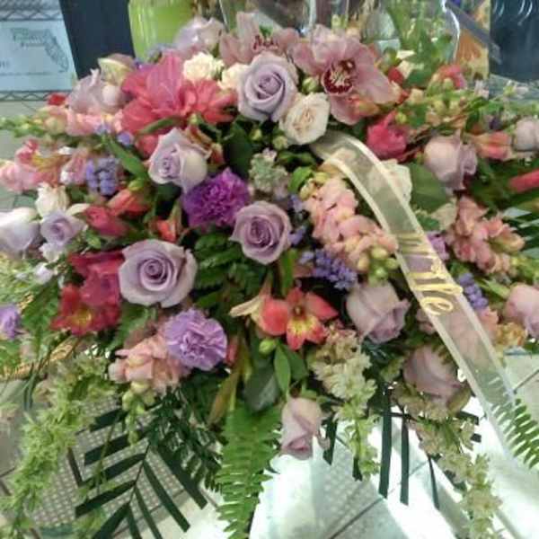 Large pastel floral spray with roses and orchids on a stand