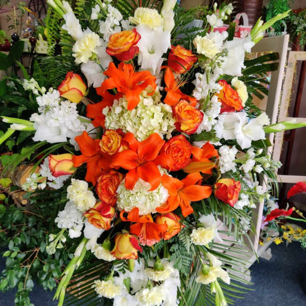 Large orange and white floral standing spray with roses and lilies