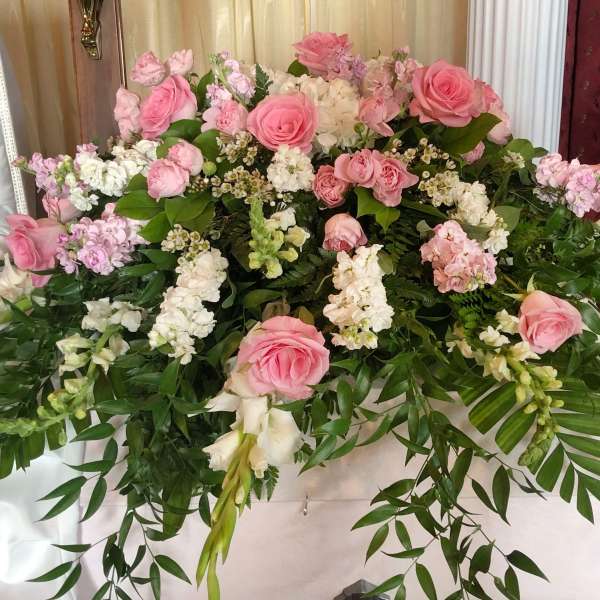 Large pink and white floral casket spray with cascading greenery