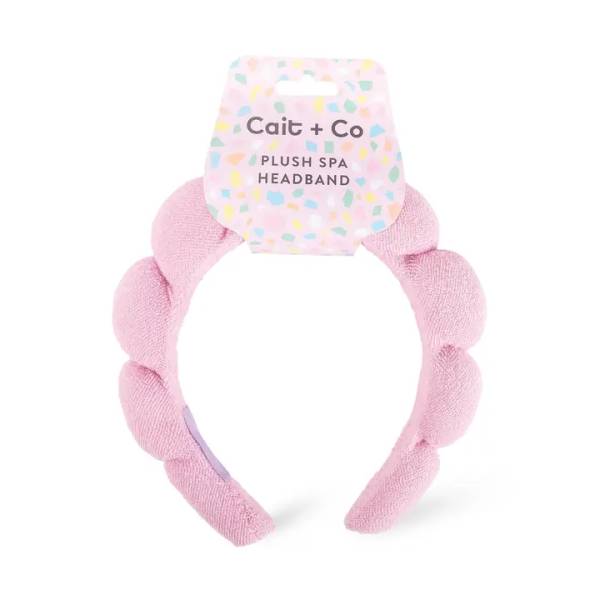 Pink plush spa headband with a branded tag