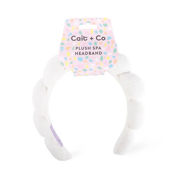 White plush spa headband with a pastel patterned tag