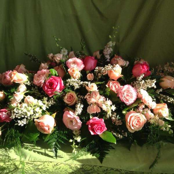 Arrangement of pink and peach roses with white filler flowers