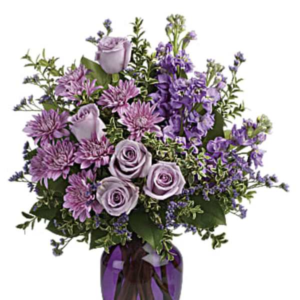 Lavender roses and purple flowers in a purple glass vase