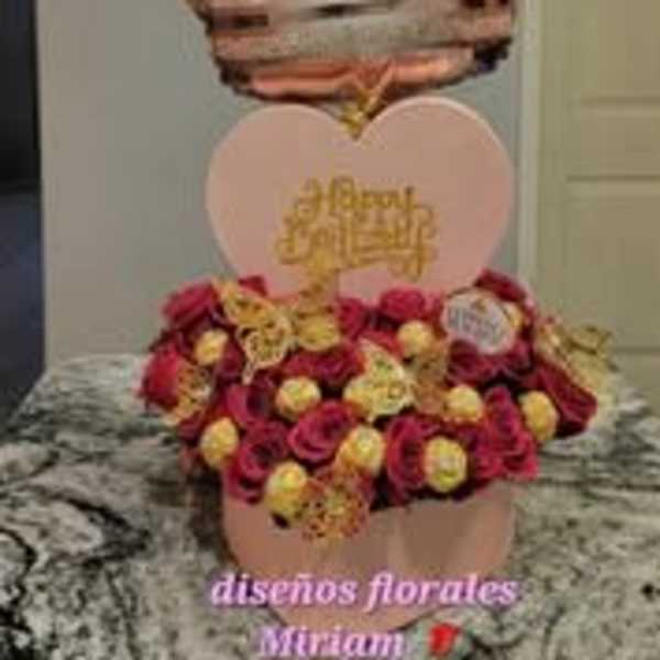 Heart-shaped rose arrangement with a crown balloon above it