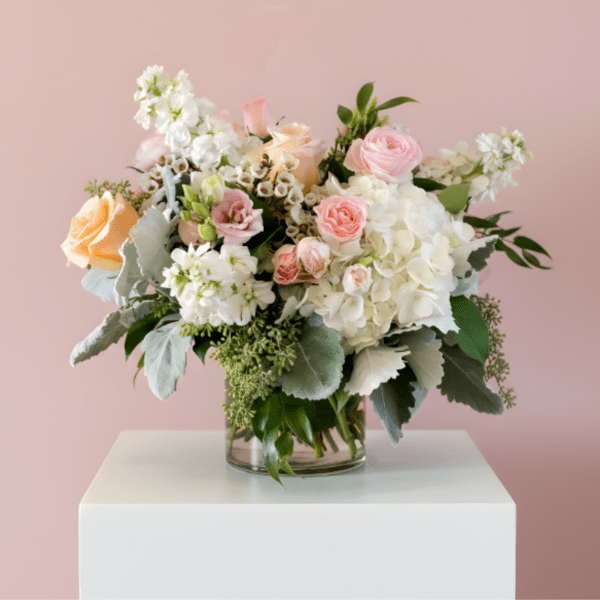 Mixed pink and white flowers arranged in a clear glass vase