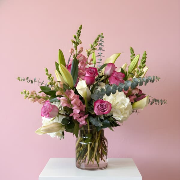 Pink and white floral arrangement in a glass vase