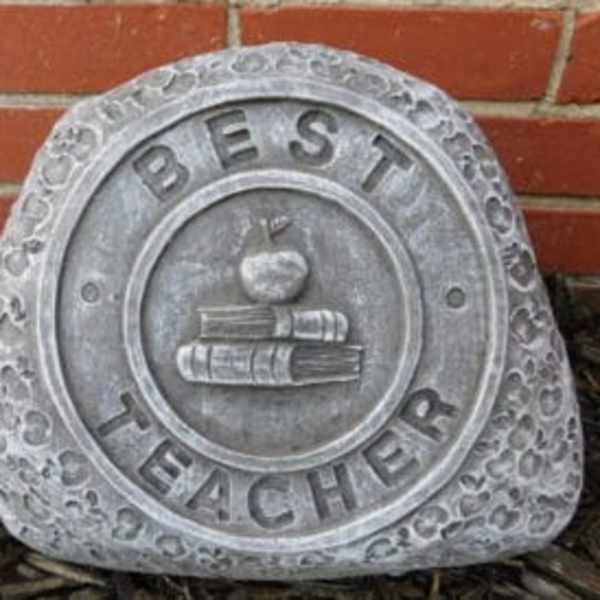 Stone plaque reading "Best Teacher" with an apple and books emblem
