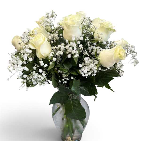 White roses and baby's breath in a clear glass vase