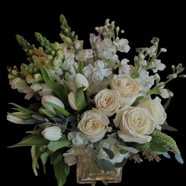 Cream roses and white flowers in a square glass vase