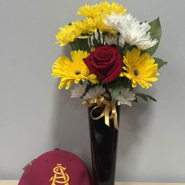 Red rose and yellow-white daisy bouquet in a black vase with a burgundy cap