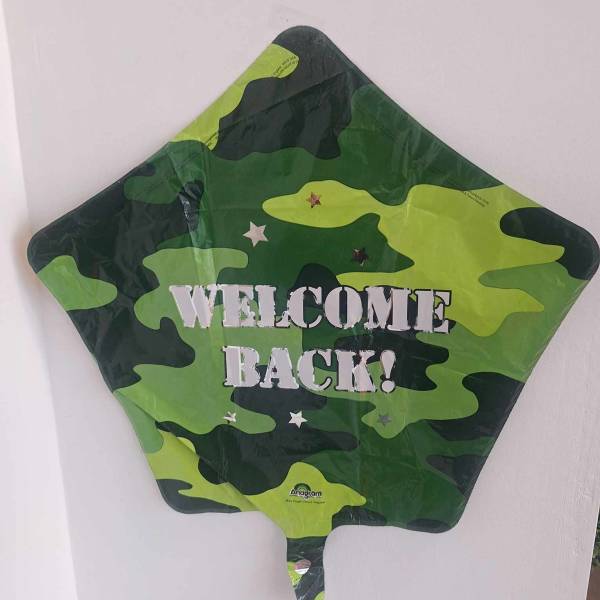 Camouflage star-shaped balloon with "WELCOME BACK!" text