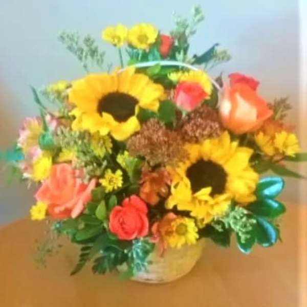 Mixed bouquet with sunflowers, roses, and daisies in a vase