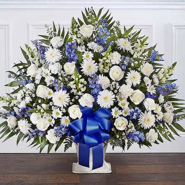 Large white and blue floral standing spray with a blue ribbon