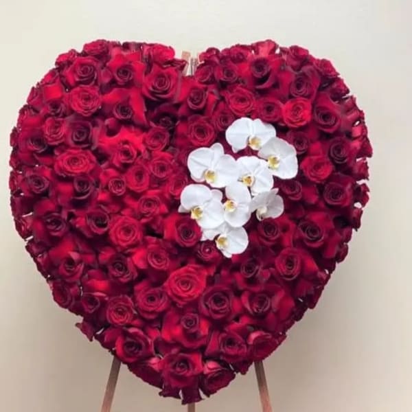 Heart-shaped arrangement of red roses with white orchids
