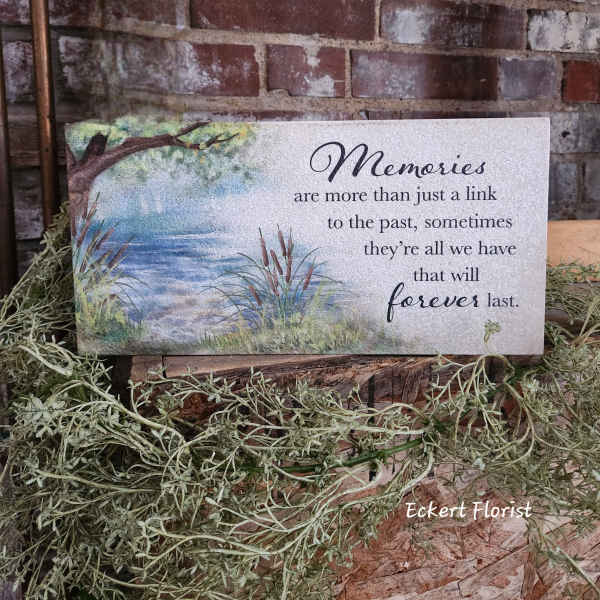 Memorial sign with a lake scene and quote on a rectangular plaque