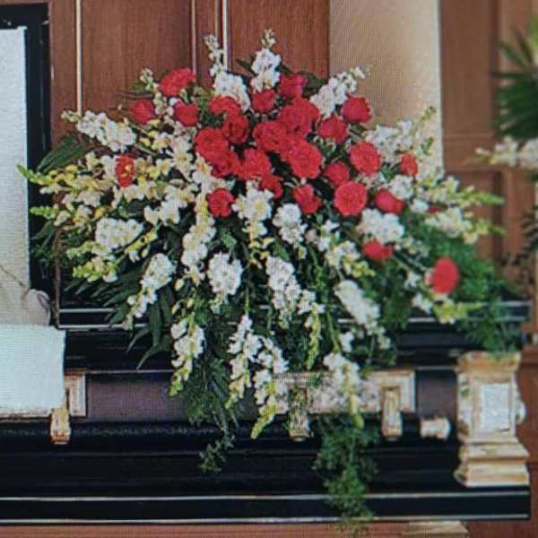 Large red and white floral spray on a piano