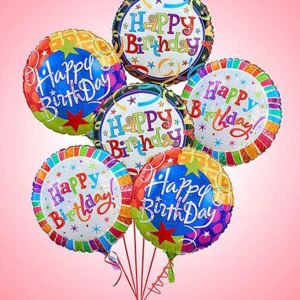 Cluster of colorful birthday balloons against a pink background
