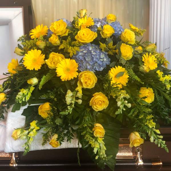 Yellow roses and daisies with blue hydrangea in a casket spray