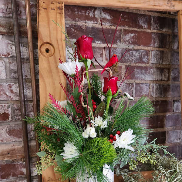 Red roses and white daisies in a birch-print container
