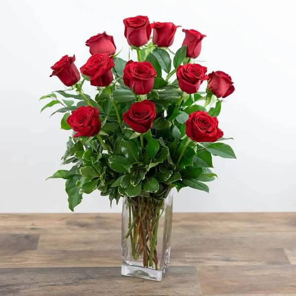 Red roses arranged in a clear glass vase