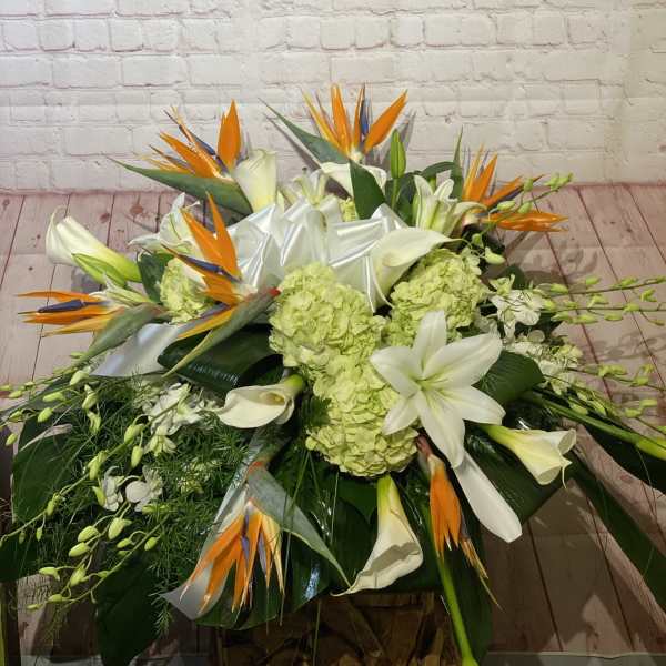 Large tropical floral arrangement with white lilies and orange bird-of-paradise