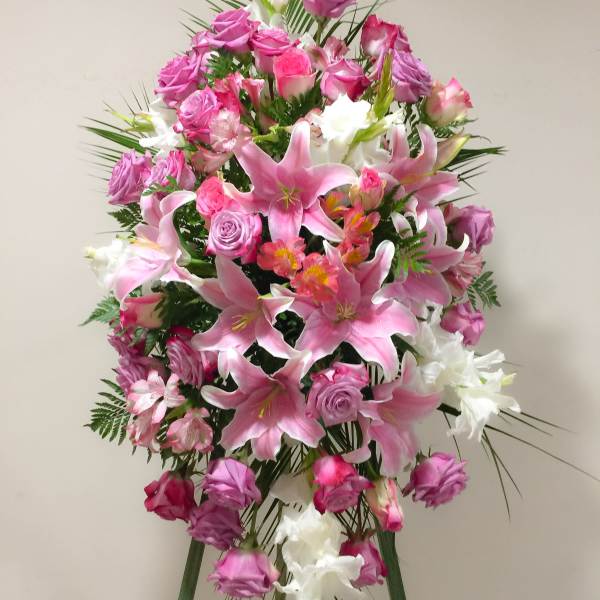 Tall standing floral spray with pink lilies, roses, and white blooms