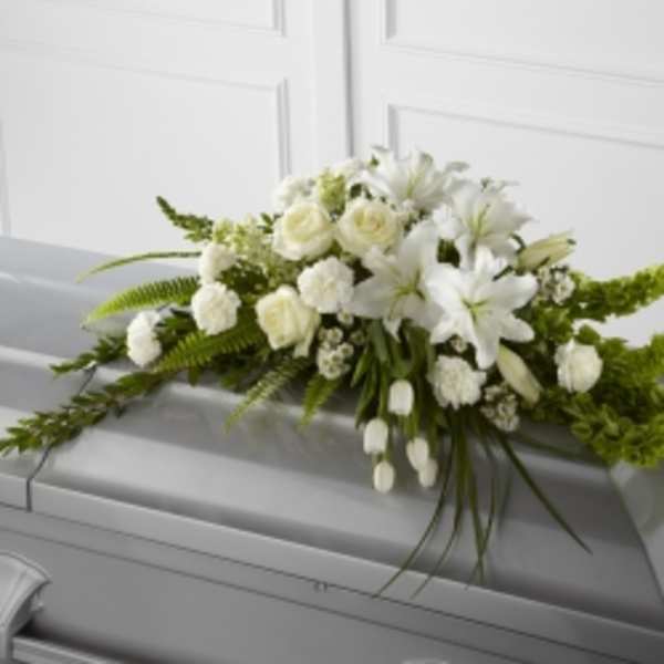 White floral casket spray with lilies and roses