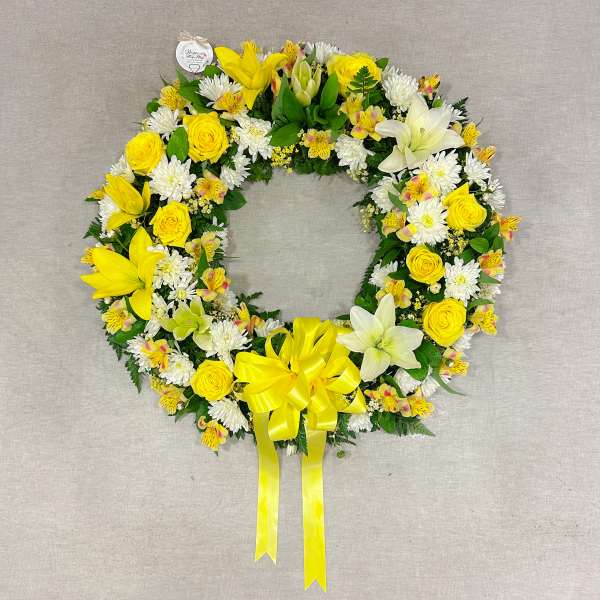 Yellow and white floral wreath with a ribbon bow