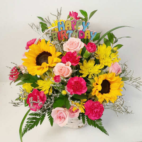 Basket bouquet with sunflowers, pink roses, and a Happy Birthday topper
