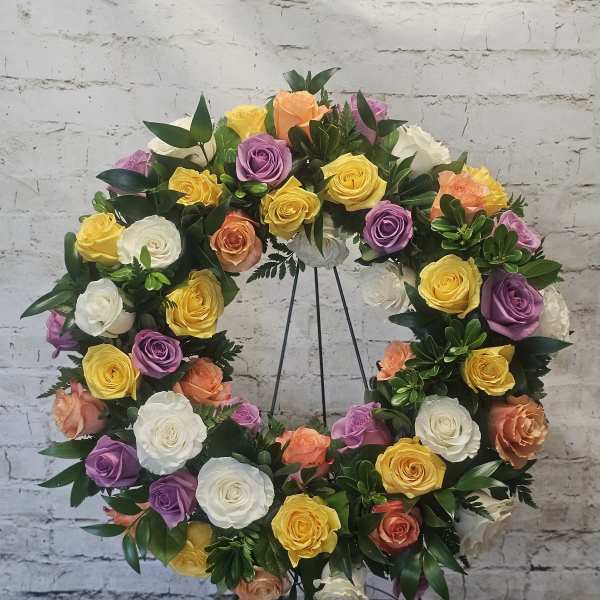 Circular wreath of multicolored roses on a metal stand