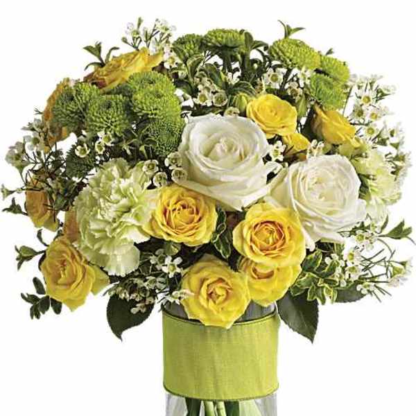 Bouquet of yellow and white roses with green mums in a glass vase