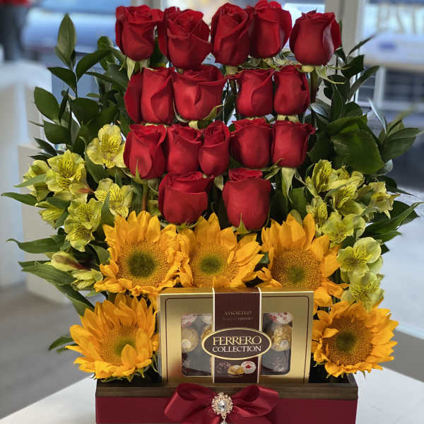 Red roses and sunflowers arranged with chocolates in a wooden gift box