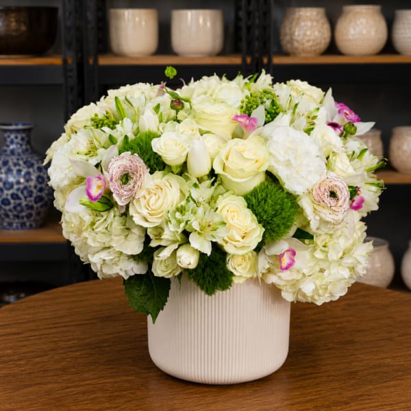 White floral arrangement in a ribbed ceramic vase