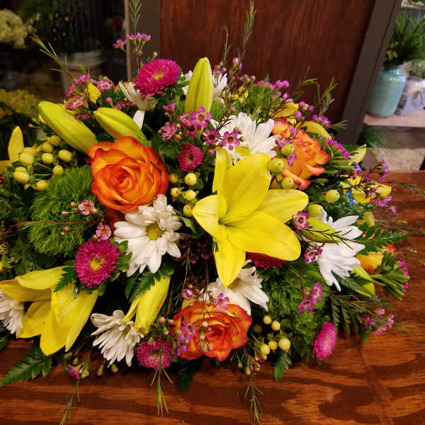 Bright mixed bouquet with yellow lilies, orange roses, and white daisies
