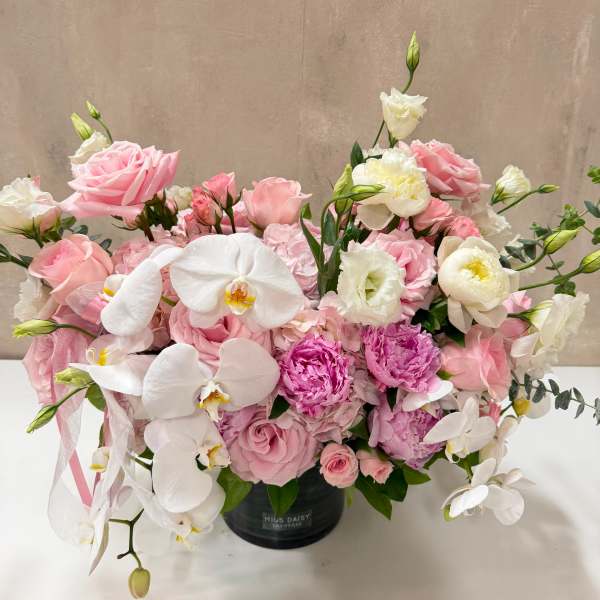 Pink and white floral arrangement in a black vase