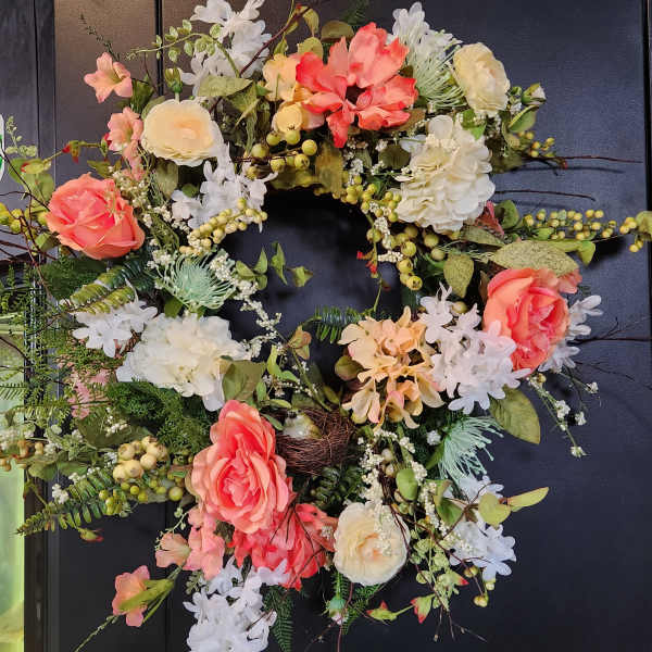 Floral wreath with coral and white blooms on a dark background