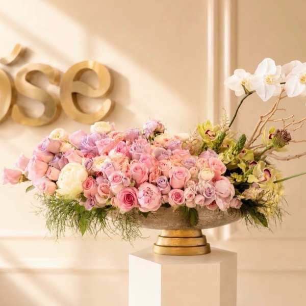 Pastel pink and white floral arrangement in a low pedestal bowl
