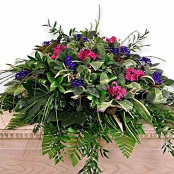 Large floral arrangement with pink and purple blooms and cascading greenery