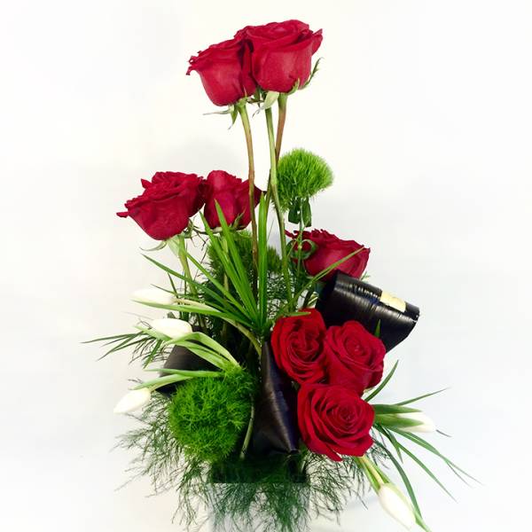 Tall arrangement of red roses with white calla lilies in a vase