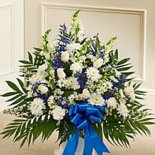 White and blue funeral spray with a blue ribbon