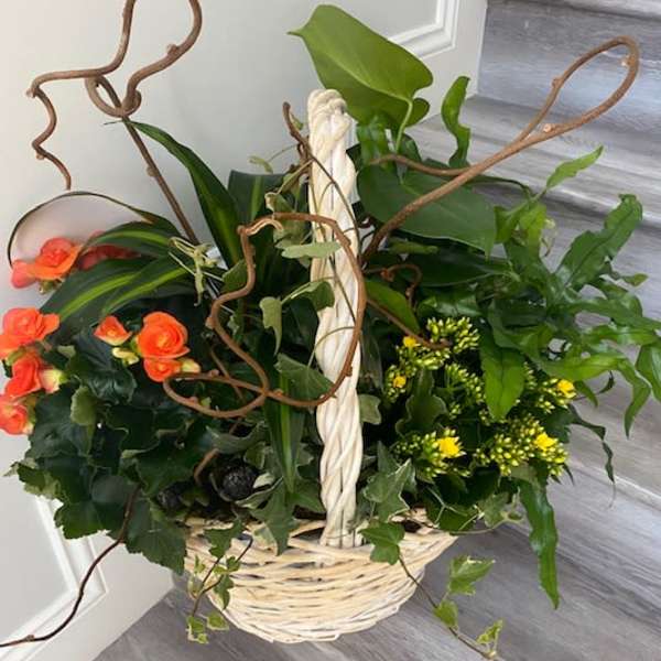 Basket arrangement with orange roses and yellow flowers