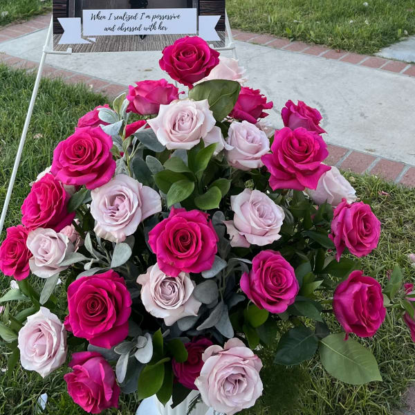 Pink and pale roses arranged in a white vase outdoors
