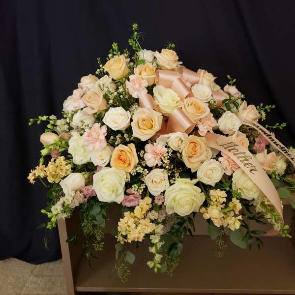 Large bouquet of cream and peach roses with ribbon on a box