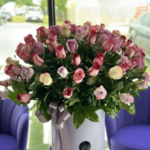 Large bouquet of pink and cream roses in a white hat box with ribbon