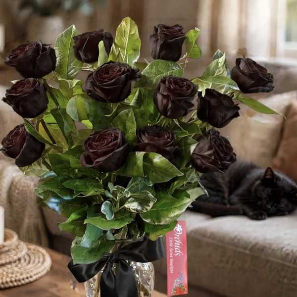 Bouquet of dark roses in a glass vase with a black ribbon