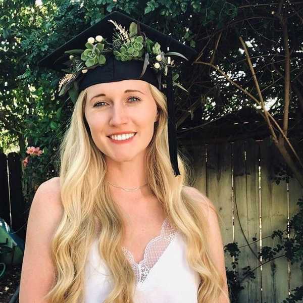 Woman wearing a black graduation cap decorated with succulents