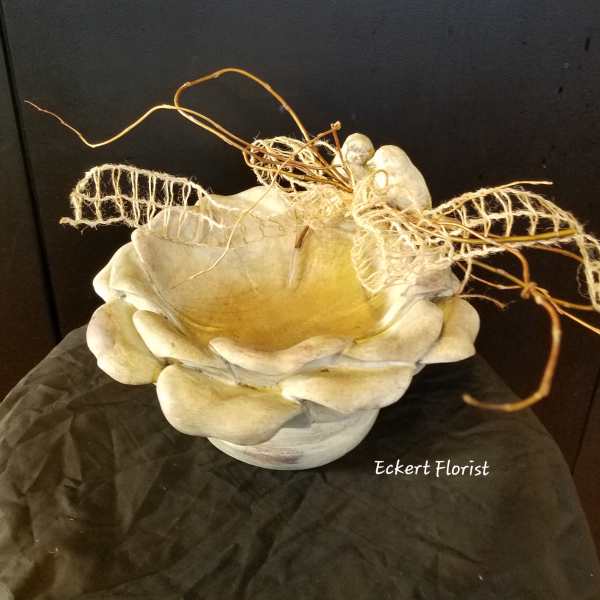 Cream-colored decorative bowl with dried twigs and mesh accents